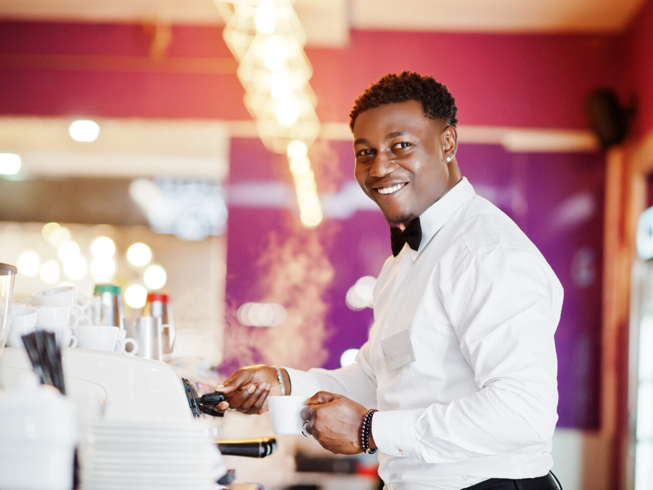 African american bartender barista at bar preparing coffee.